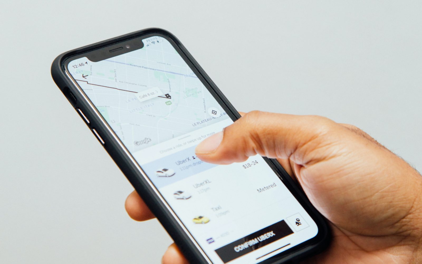 Person holding a smartphone, requesting a rideshare
