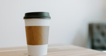 A nondescript cup off coffee from a fast food restaurant sits on a table. Tim Hortons employees are entitled to severance pay when they lose their job.