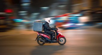 A person conducts food deliveries on their moped. Doordash employees are entitled to full severance pay when they lose their job.