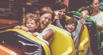 A photo of parents with their children on a rollercoaster. (Photo: Chris Slupski / Unsplash)