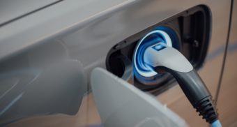 A glowing charging socket is plugged into an electric vehicle. VinFast LLC employees are entitled to severance when they lose their job.