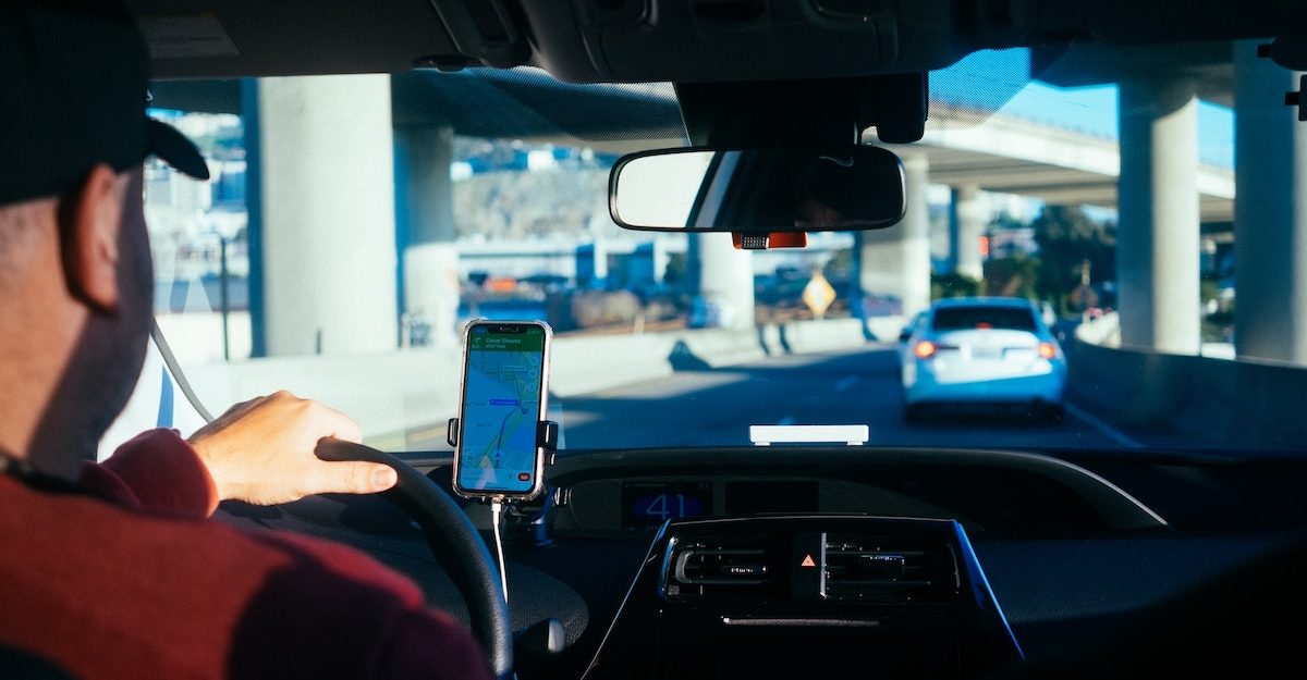 A Lyft driver relies on his dash-mounted map app as he navigates a highway underpass. Lyft employees are entitled to severance pay when they lose their job.