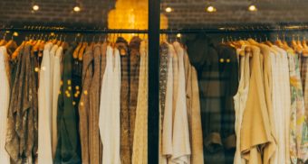 A photo of clothing on a rack in a store. (Phone: Hannah Morgan / Unsplash)