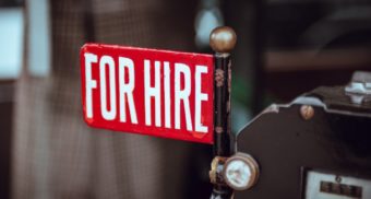 A red 'for hire' sign attached to a black pole. ZipRecruiter employees are entitled to full severance pay.