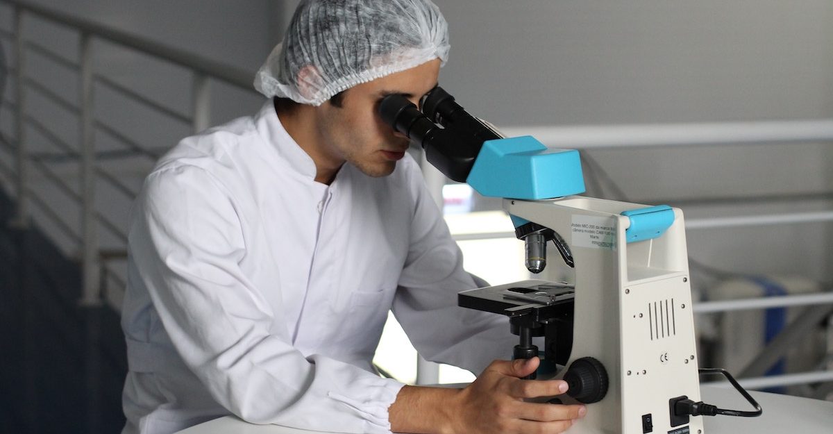 A DynaCare employee examines a sample through a microscope in one of the company's labs.