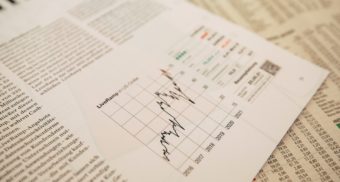 A sheet displaying financial information sits on top of the stock section of a newspaper. Prospera Credit Union employees are entitled to full severance when they lose their job.