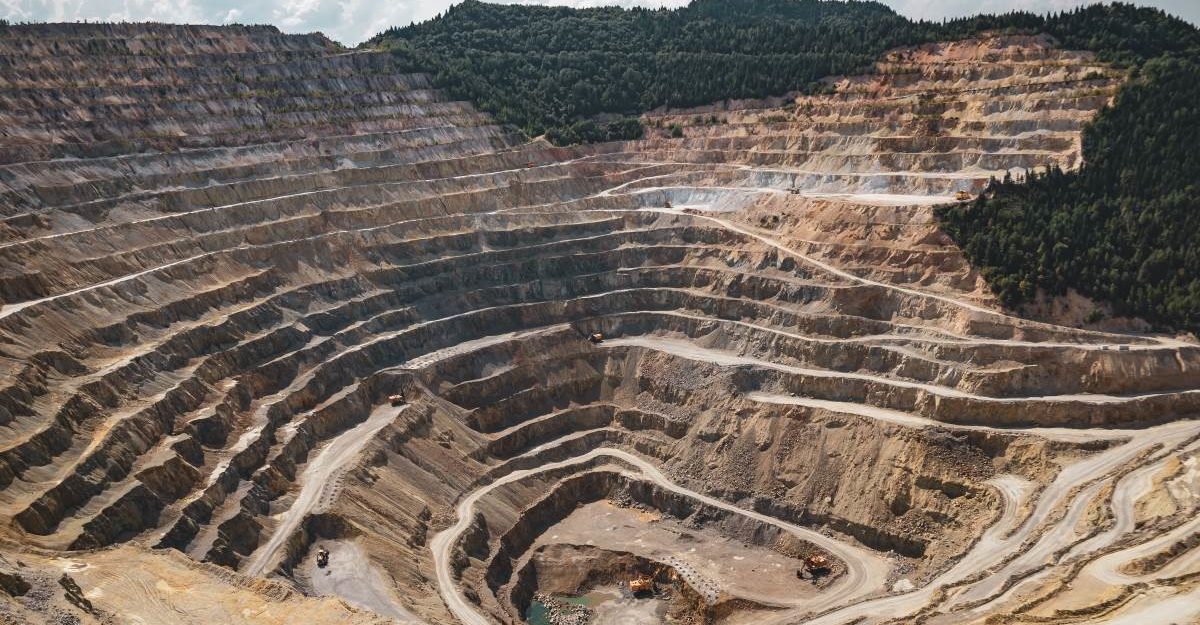 A vast open-pit mine descends deep into the Earth's crust. Mining industry employees are entitled to full severance packages.