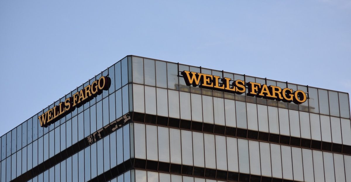 The Wells Fargo name adorns the top of a large office building topped with clear blue sky