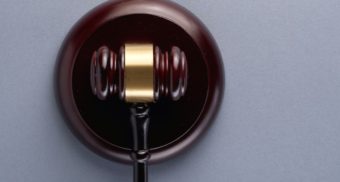 A photo of a gavel on a grey table. (Photo: Eskay Lim / Unsplash)