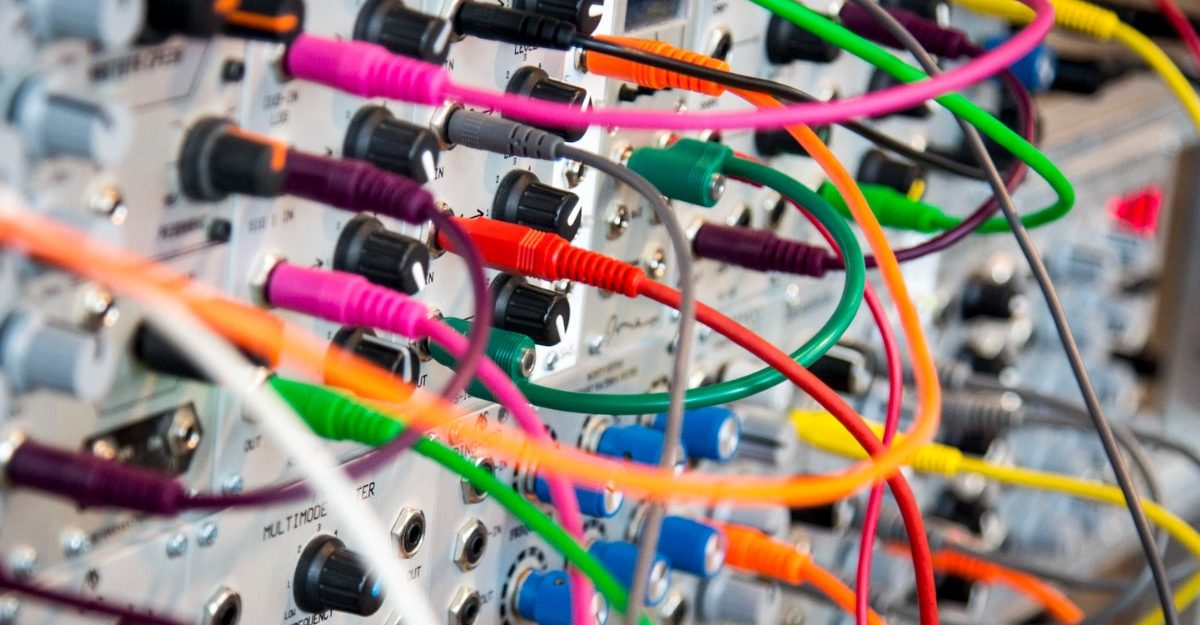 A photo of various cables plugged into outlets. (Photo: John Barkiple / Unsplash)