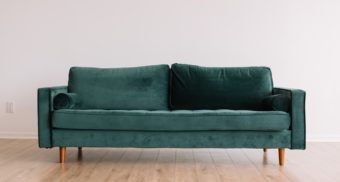 A simple green sofa, potentially sold by Bad Boy Furniture in Ontario.