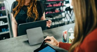 A customer uses a digital terminal to pay for their purchase.