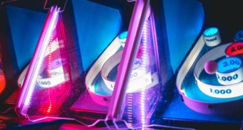 A photo of skee-ball machines with neon lights. (Photo: Rhett Wesley / Unsplash)