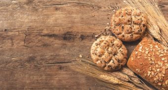 A photo of bread and wheat on a wooden table. (Photo: Ales Krivec / Unsplash)