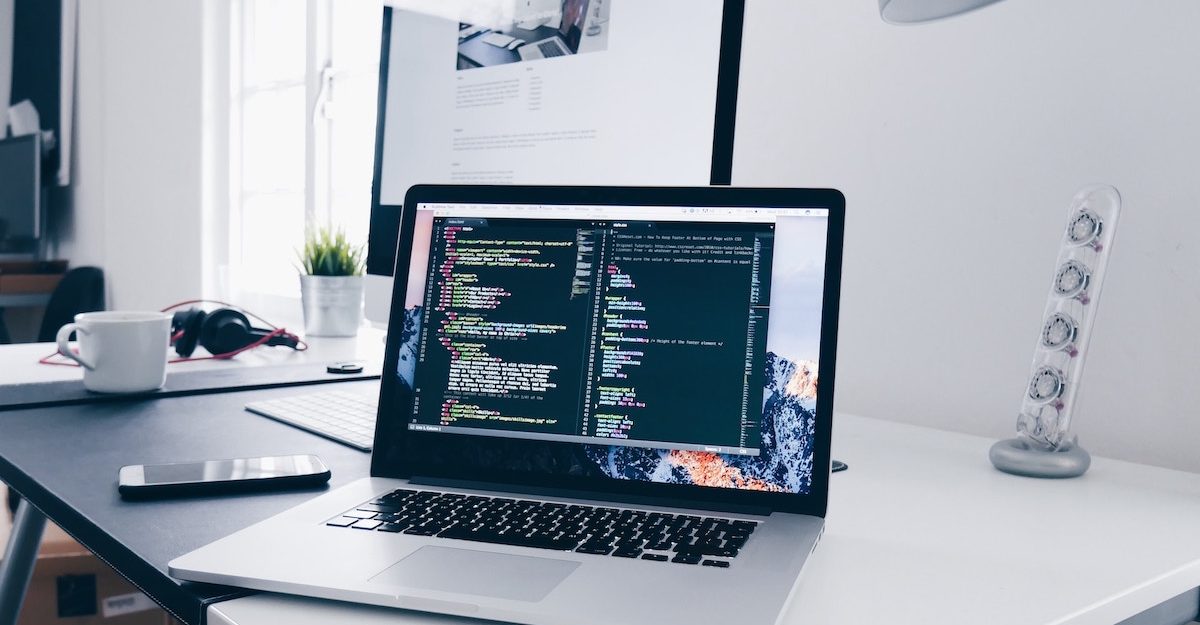 A laptop sits open on a clean white table, displaying software that is likely similar to what PointClickCare uses.