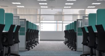 Rows of empty workstations sit on either side of the aisle.