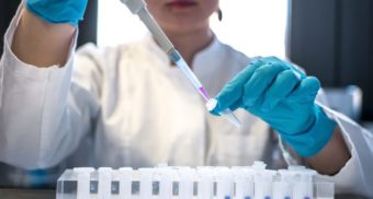 A medical professional working in laboratory. Pharmaceutical industry workers are owed severance pay when they're laid off or fired.