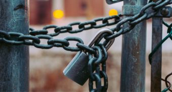 A photo of a gate closed with chains and a lock. (Photo: Jose Fontano / Unsplash)