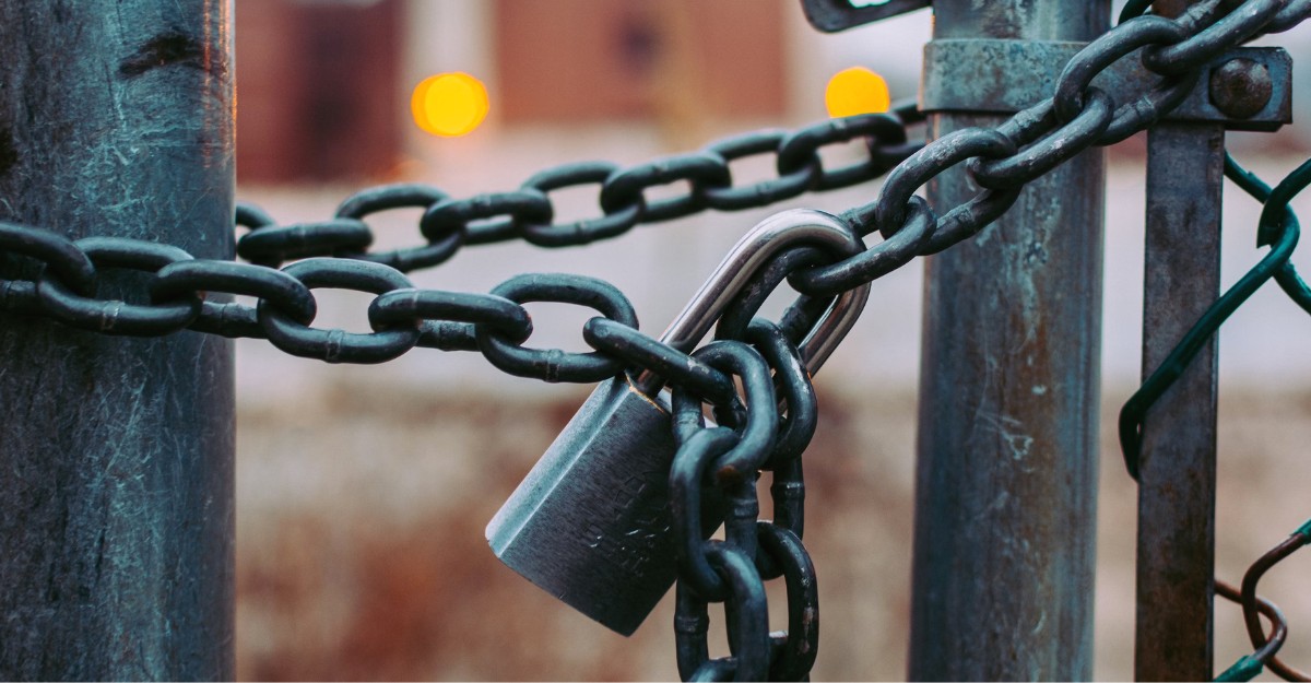 A photo of a gate closed with chains and a lock. (Photo: Jose Fontano / Unsplash)