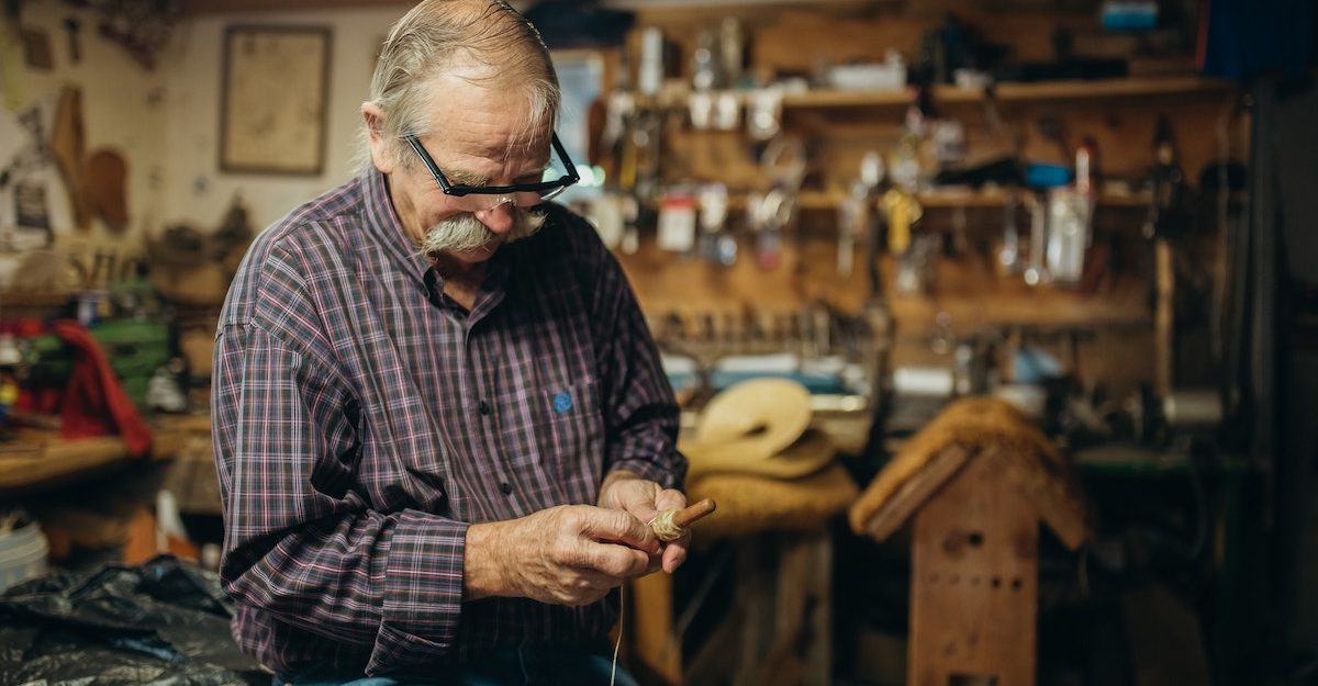 An older man hard at work in an Ontario workplace, potentially being forced to retire due to his age.