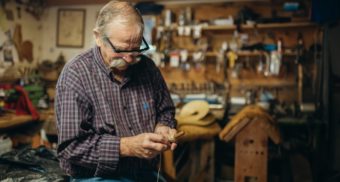 An older man hard at work in an Ontario workplace, potentially being forced to retire due to his age.