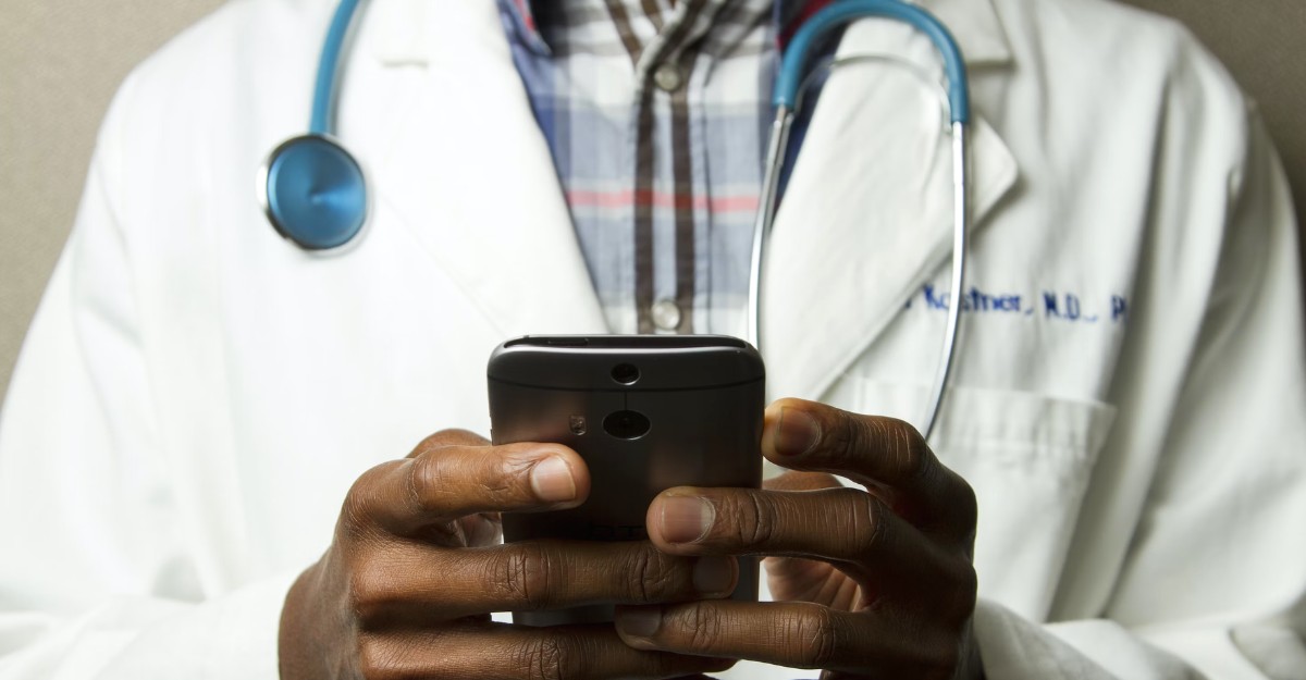 A photo of a doctor looking at a phone. (Photo: National Cancer Institute / Unsplash)