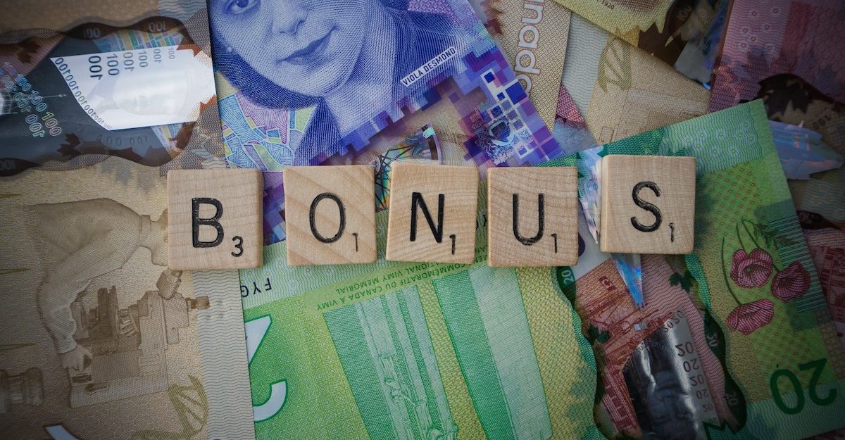 Scrabble letters spelling 'bonus' on Canadian bills.