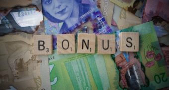 Scrabble letters spelling 'bonus' on Canadian bills.