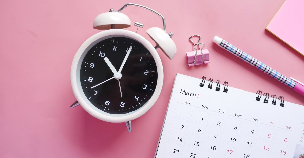 A photo of a pink clock and calendar on a pink table. (Photo: Towfiqu barbhuiya / Unsplash)