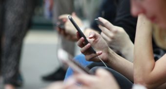 A photo of people interacting with their phones. (Photo: ROBIN WORRALL / Unsplash)