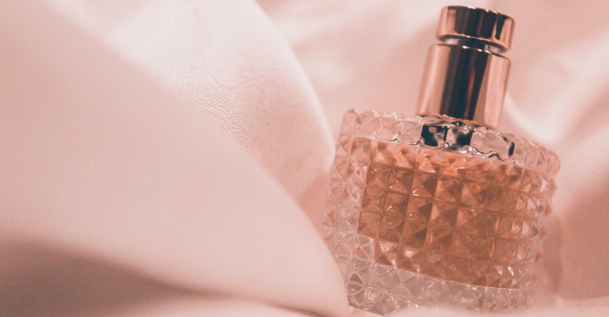 A photo of a perfume bottle on a sheet of fabric. (Photo: siora18 / Unsplash)