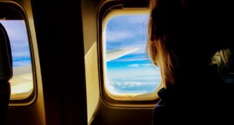 A photo of a person looking out the window of an airplane. (Photo: Tim Gouw / Unsplash)