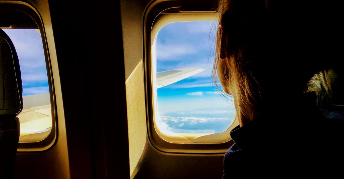 A photo of a person looking out the window of an airplane. (Photo: Tim Gouw / Unsplash)