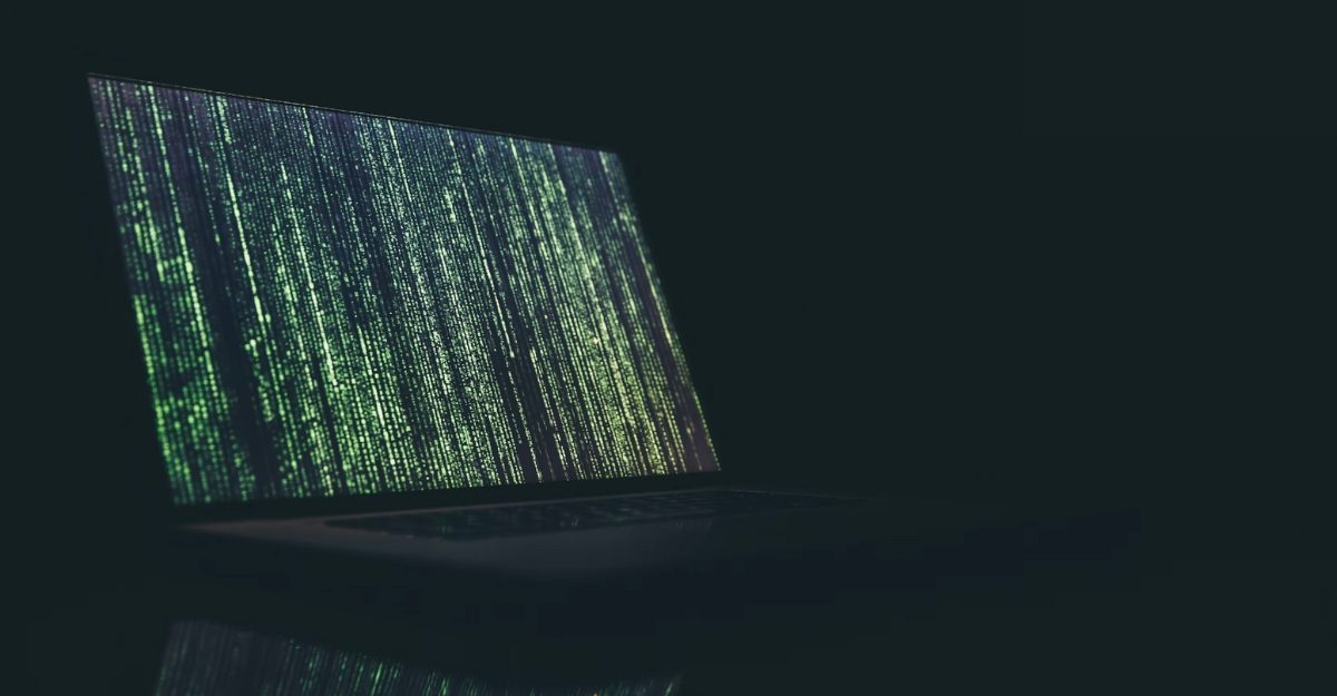 A photo of a laptop with code moving across the screen. (Photo: Markus Spiske / Unsplash)