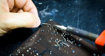 A photo of a person soldering an electronic device. (Photo: Blaz Erzetic / Unsplash)