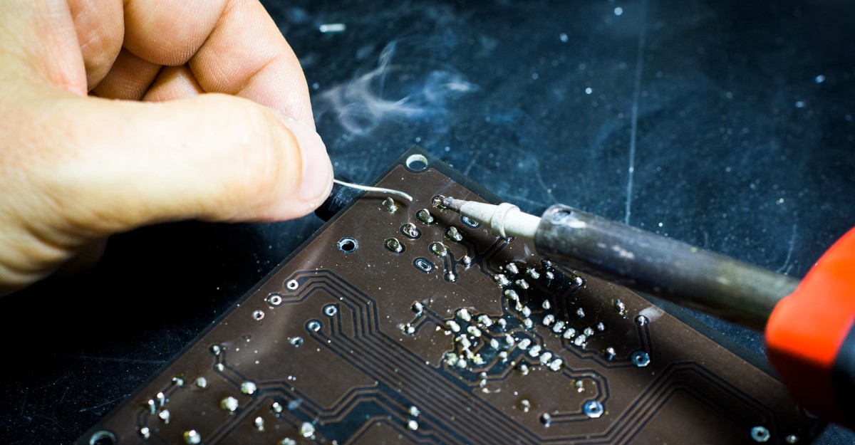 A photo of a person soldering an electronic device. (Photo: Blaz Erzetic / Unsplash)