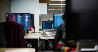 People sitting at a table, learning coding.