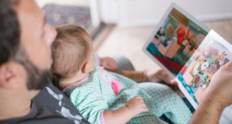 A father reading to his child during paternity leave in Alberta.