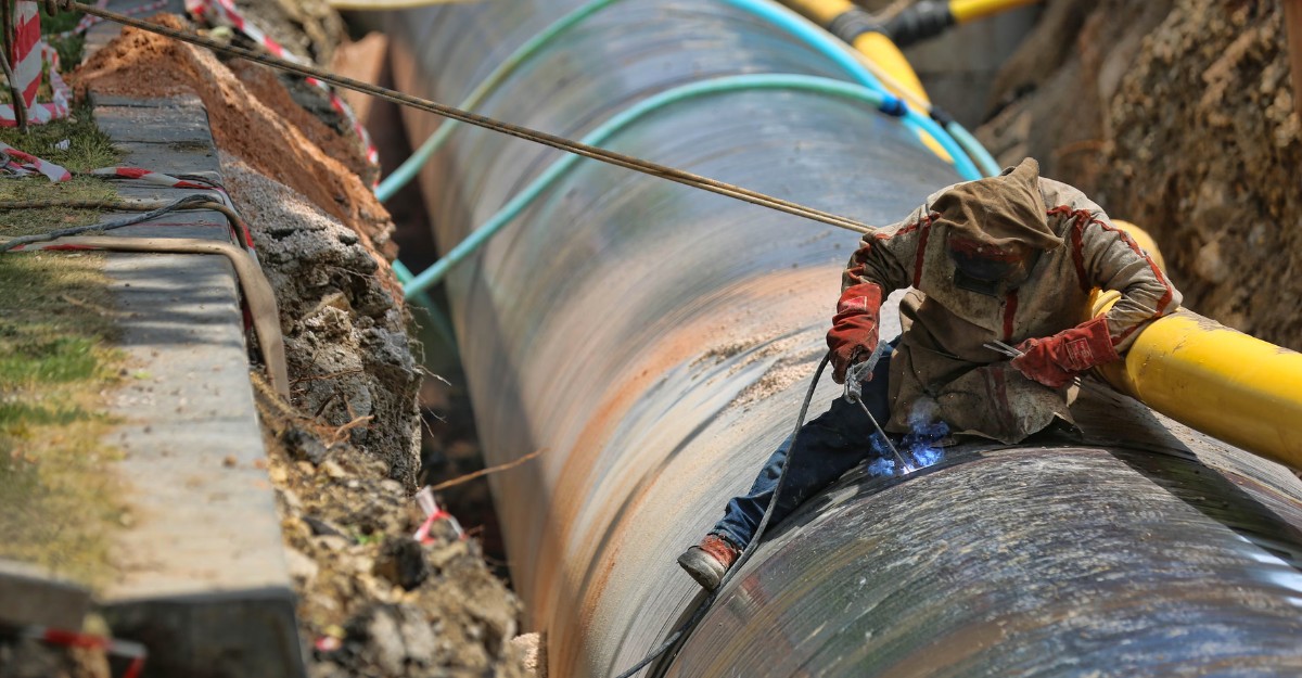 A photo of a person helping to build a pipeline. (Photo: SELİM ARDA ERYILMAZ / Unsplash)