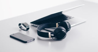 A photo of various tech gadgets on a white table. (Photo: Christopher Gower / Unsplash)