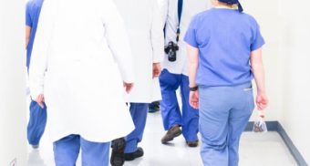 A photo of medical professionals walking down a hallway. (Photo: Luis Melendez / Unsplash)