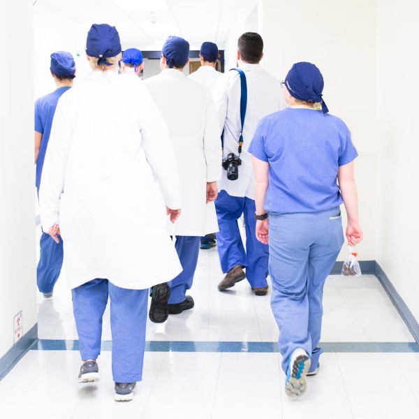 A photo of medical professionals walking down a hallway. (Photo: Luis Melendez / Unsplash)