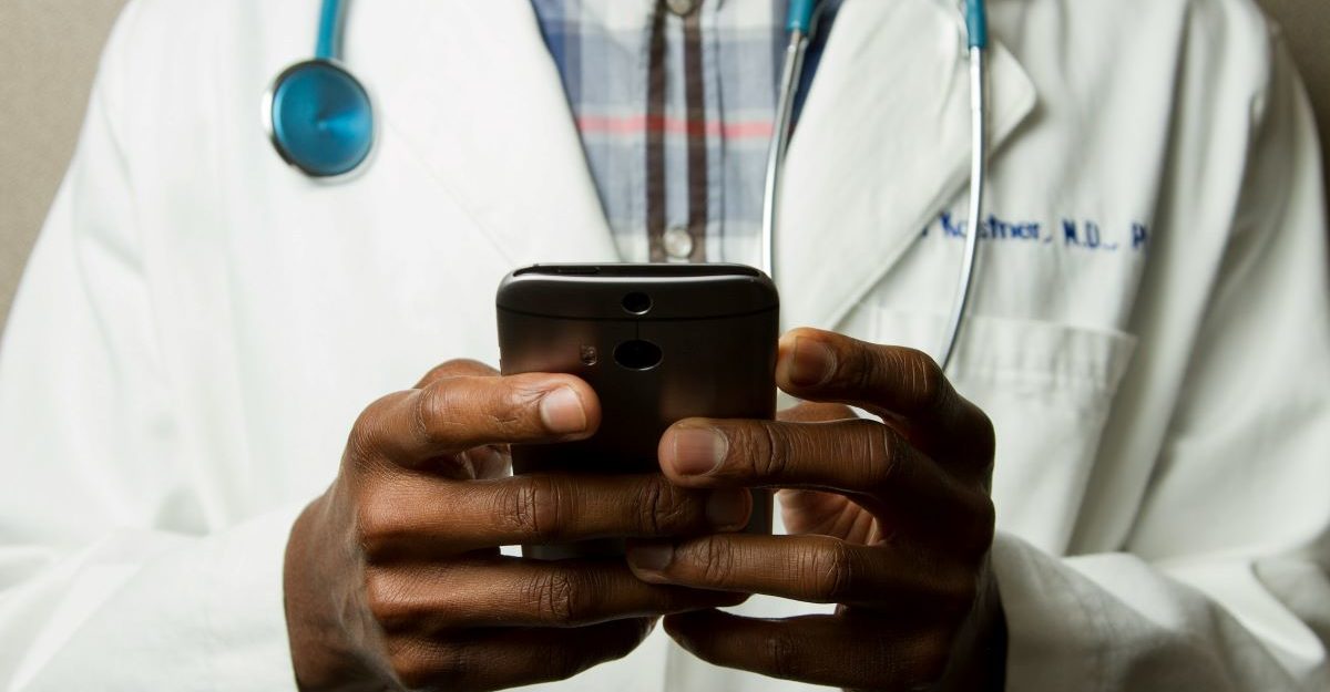 A doctor using software, potentially provided by PX Solutions, on their smartphone.