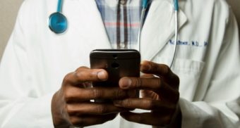 A doctor using software, potentially provided by PX Solutions, on their smartphone.