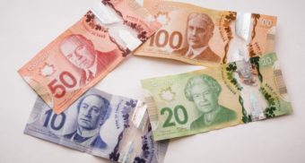 A photo of four Canadian bills on a table. (Photo: PiggyBank / Unsplash)