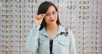 A woman tries on a pair of glasses, potentially in an FYidoctors location.