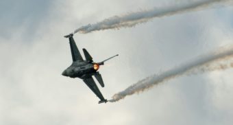 A close up shot of a fighter jet, potentially built by General Dynamics, streaking across the sky.