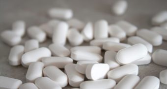A collection of white pills, potentially manufactured by Kenvue.