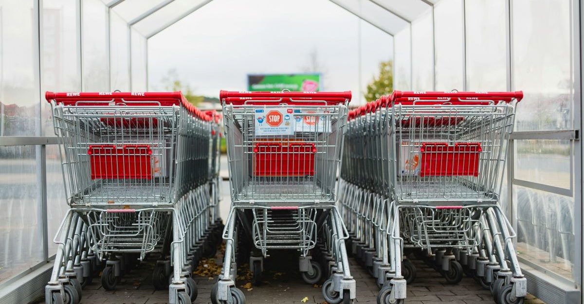 Many shopping cars gathered under a canopy, potentially at a Giant TIger location.