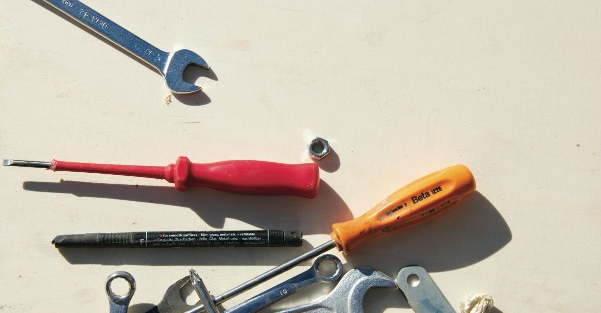 A number of tools lie scattered on a surface, potentially sold by Grainger Canada.